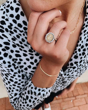 Young woman wearing a gold custom Texas Tech class ring surrounded by diamonds.