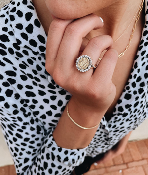 Young woman wearing a gold custom Texas Tech class ring surrounded by diamonds.